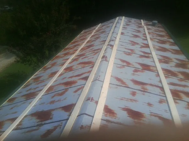 Rusted metal roof panels with new wood purlins before replacement — Storm Damage Roof Repair in Mather by Roofing Brothers