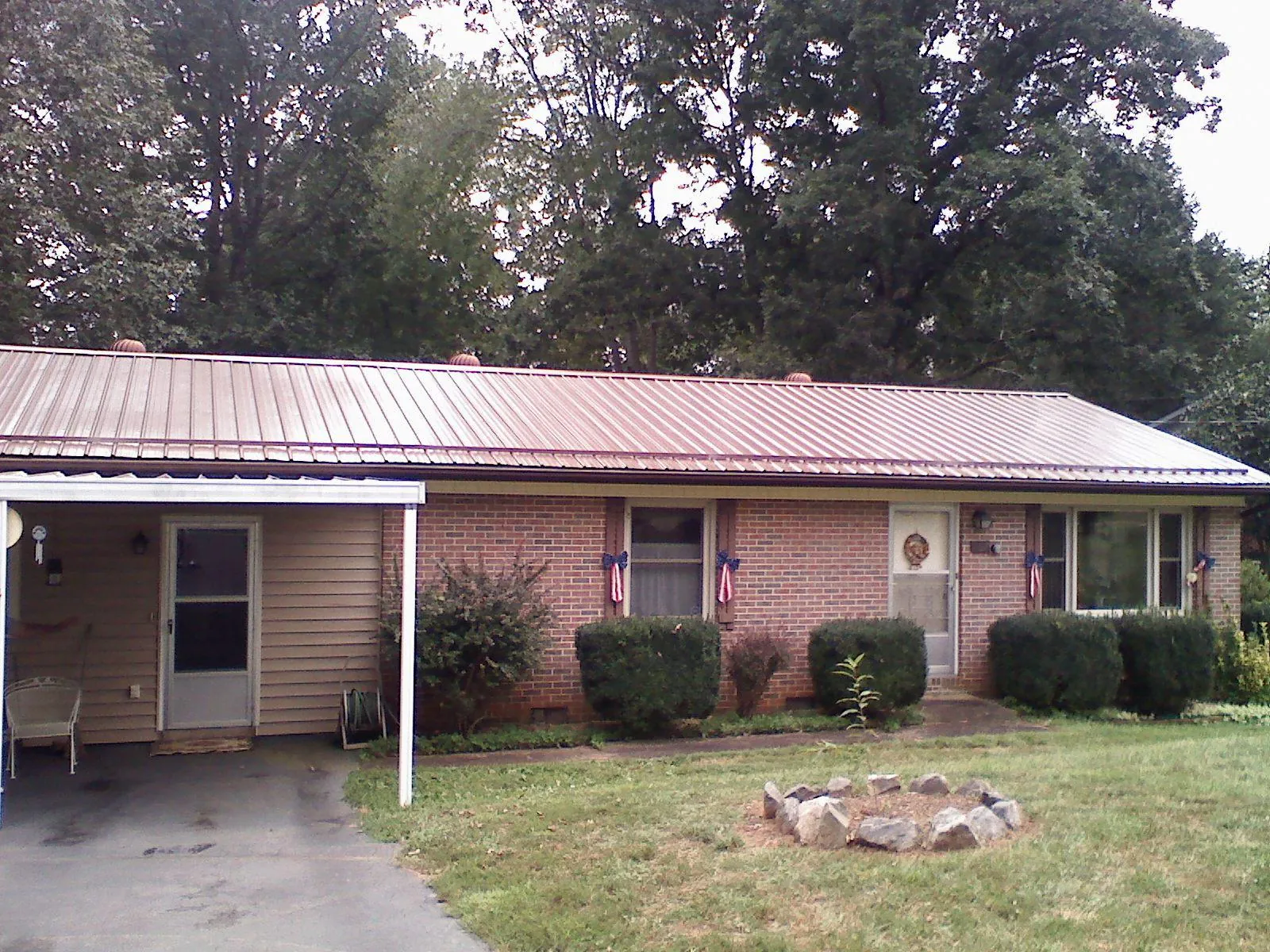 Bronze metal roof and carport on a brick ranch home — Roof Repair work by our crew in Mather
